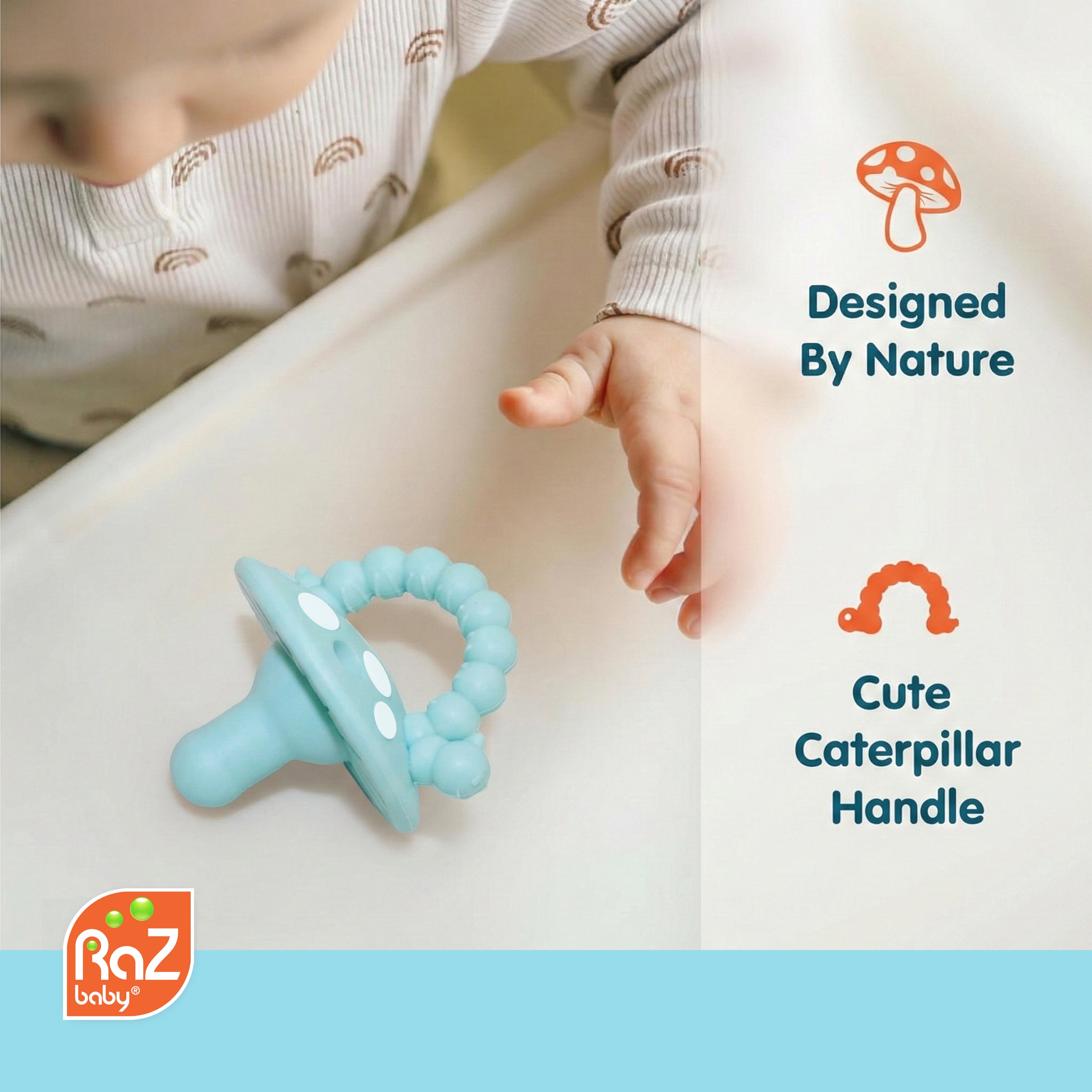 A baby pacifier teether with a light blue caterpillar handle and white polka dots, shown on a white surface next to a baby's hand. The image includes text callouts 'Designed By Nature' and 'Cute Caterpillar Handle' with the Raz baby logo in the bottom left corner.